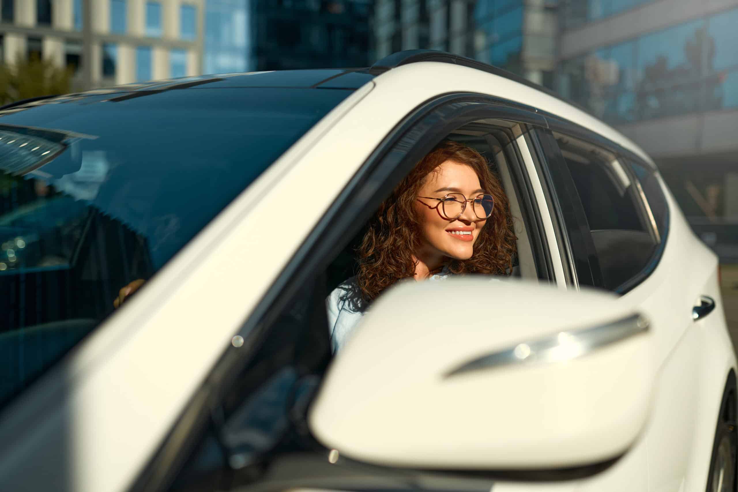 Smiling woman saving money with a car insurance discount in South Florida.